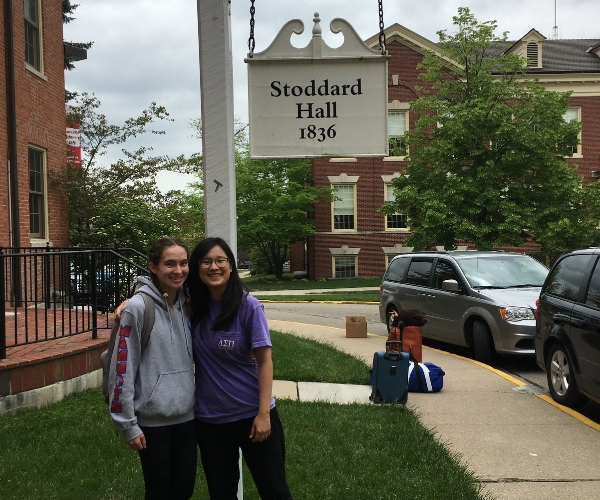 two miami students stand in front of Stoddard Hall sign