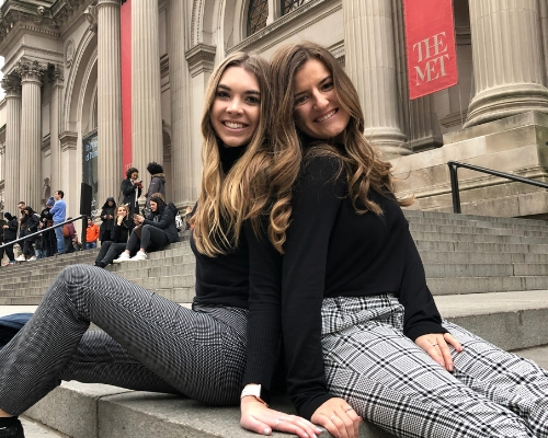  Nicole Richards sitting on steps in New York city outside with her friend