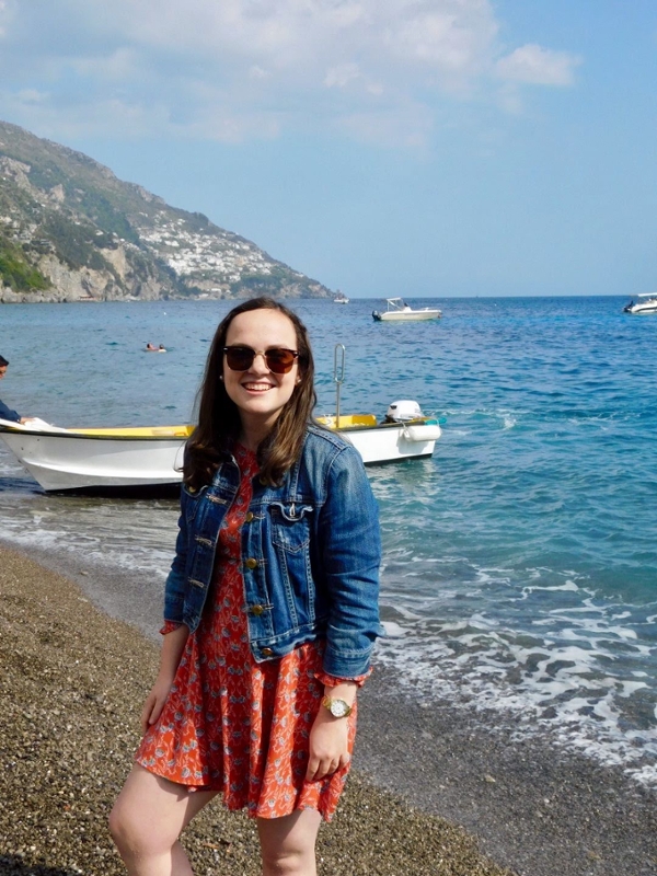 student poses in front of ocean in italy