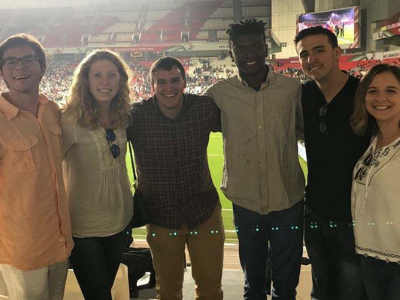 a group of students poses for a picture at a sporting event