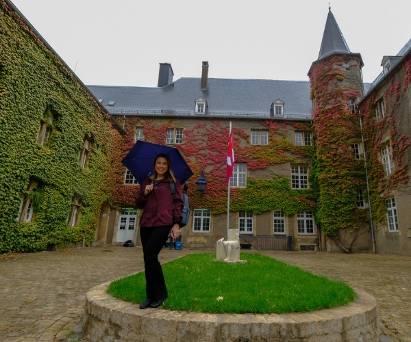 Kristin standing with an umbrella in front of the chateau: Miami University John E. Dolibois European Center in Luxembourg