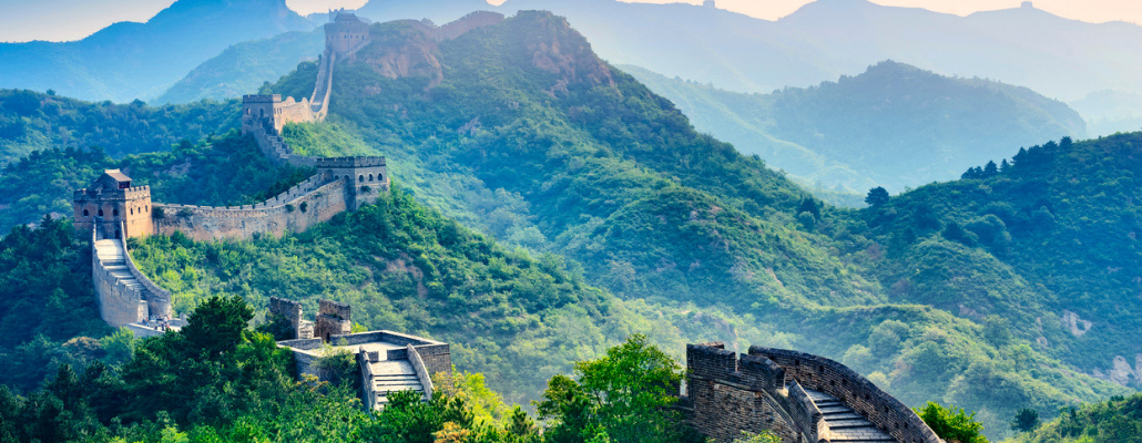 a photo of the great wall of China amidst rolling hills