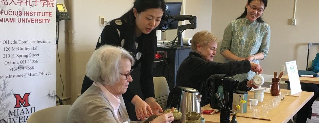 two ILR members pouring tea and two Confucius Institute staff helping them
