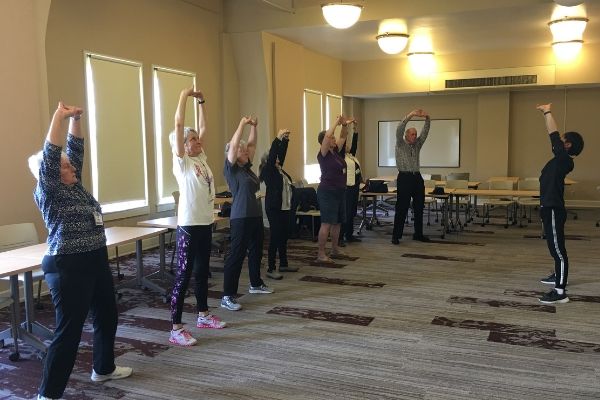 group of senior citizens stretching with Chinese martial arts instructor