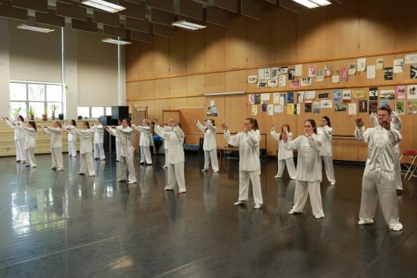 group shot of many Miami students in white uniforms practicing martial arts