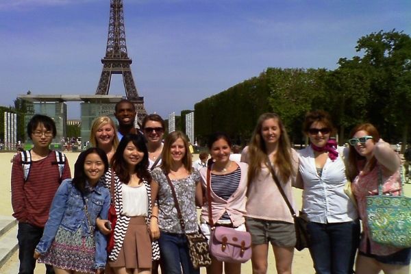Seth standing with a group of students in front of the Eiffel Tower in Paris