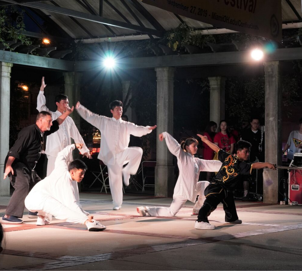 tai chi performers pose on stage