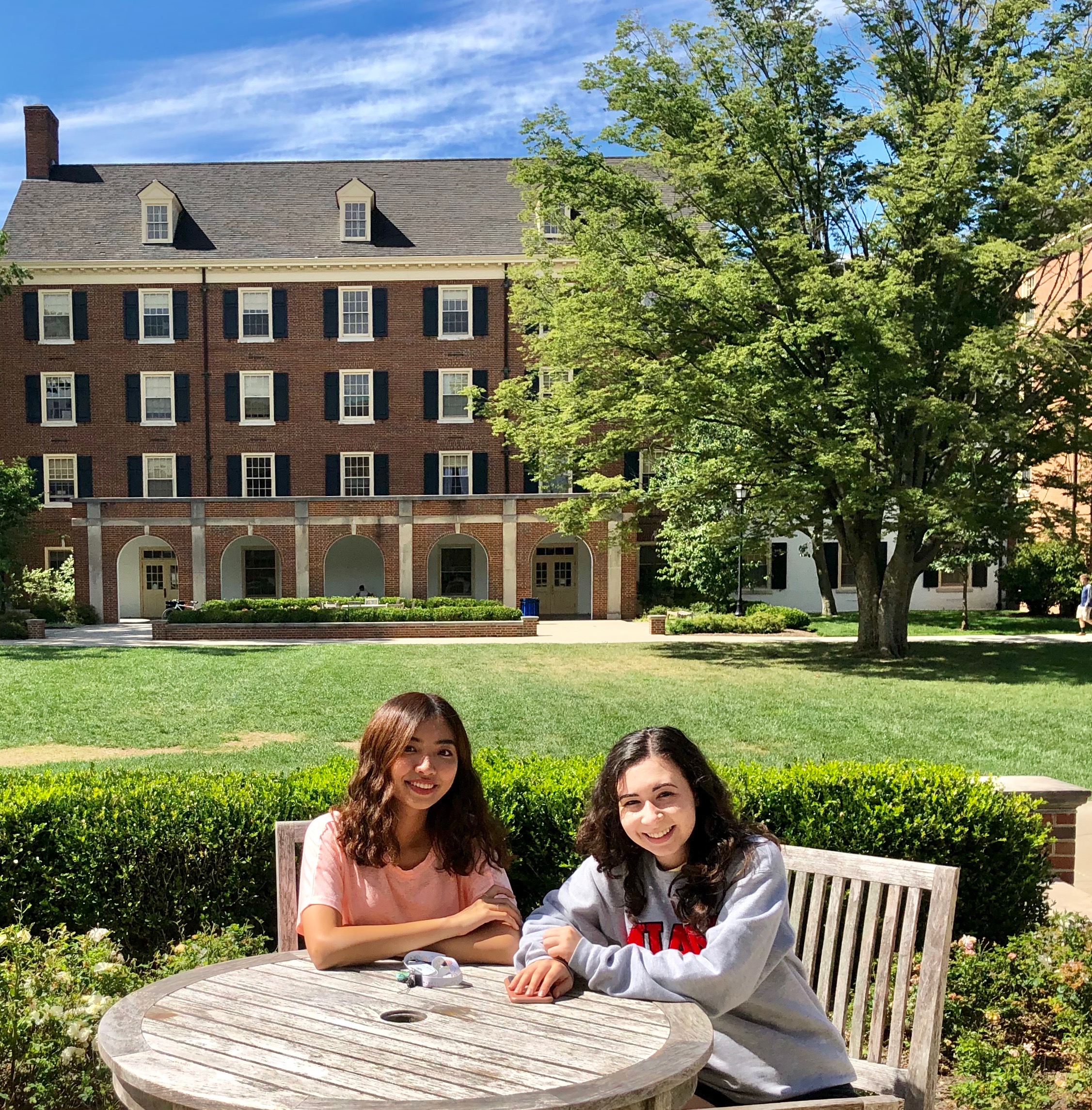 Megan and her roommate sit outside of their residence hall