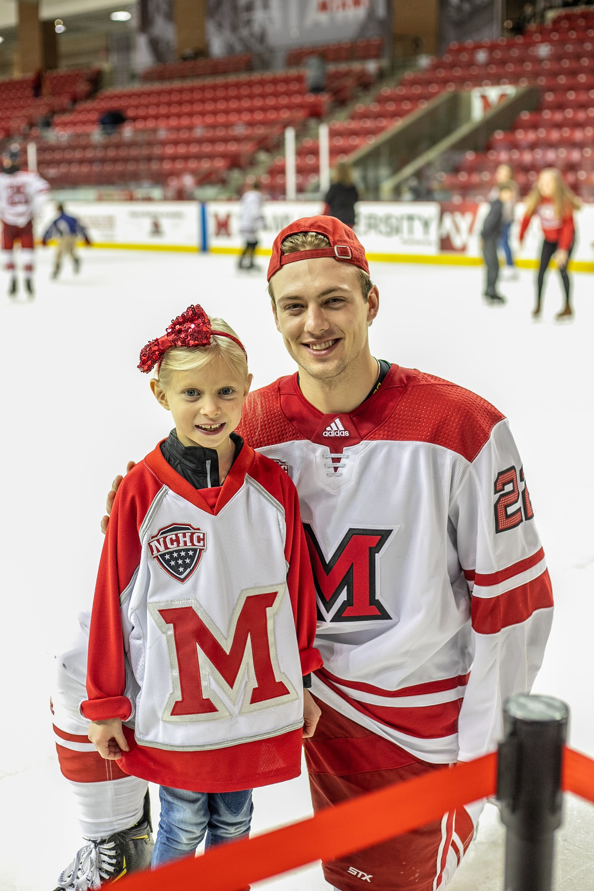 Carter poses with a young girl on the ice rink
