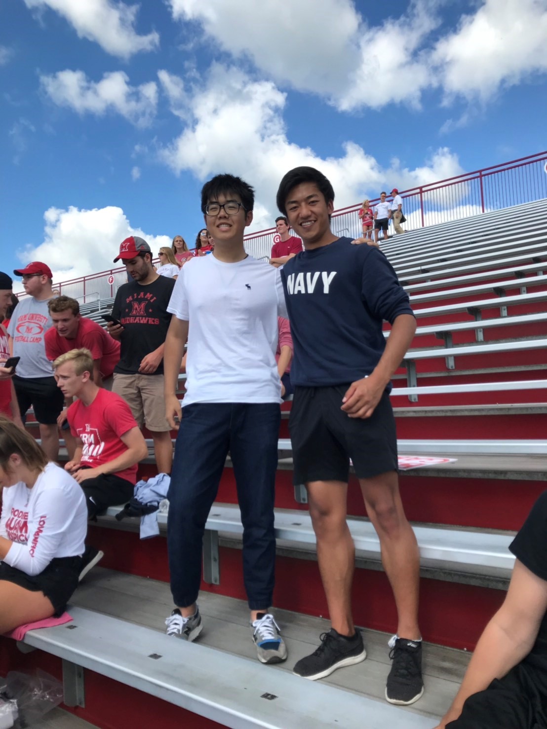 Tenen and a friend standing in the bleachers