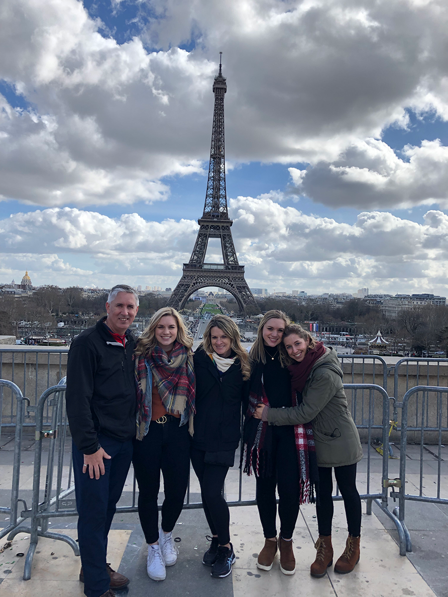 Alex and family pose in front of the Eiffel Tower
