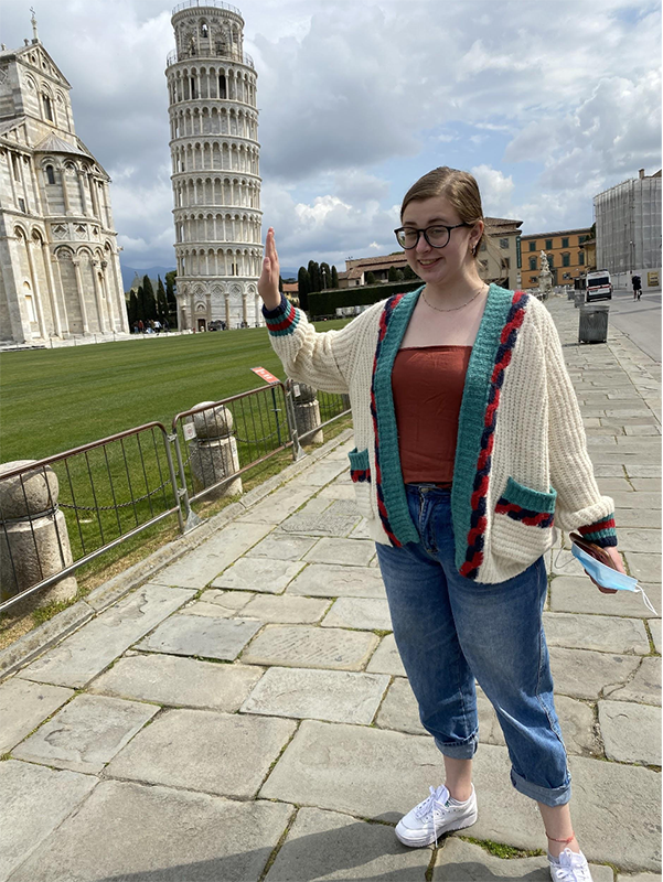 Paige poses with a hand along the Tower of Pisa