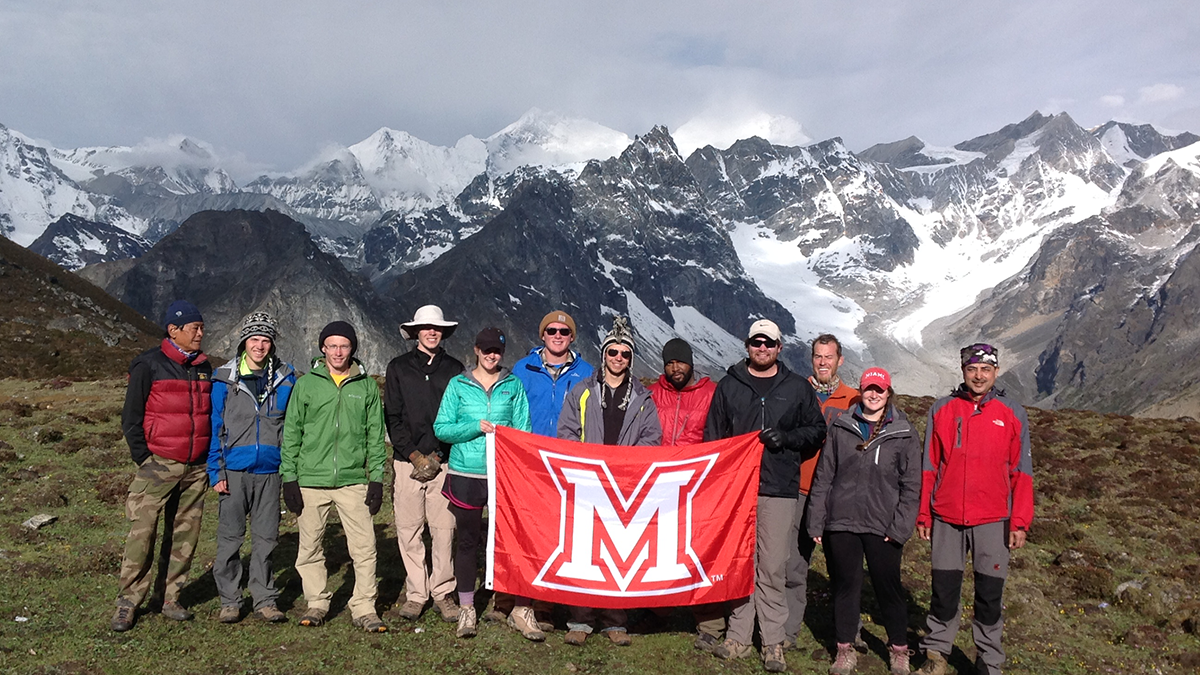  Miami students pose with an 'M' flag in the Himalayas
