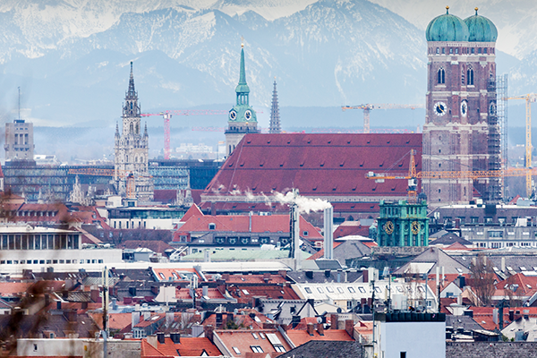 Frauenkirche Munich with snow-capped Alps and surrounding buildings