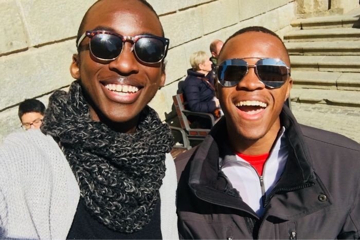 2 students wearing sunglasses and smiling