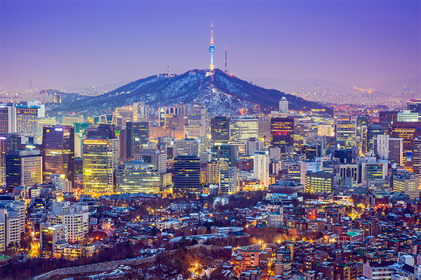 Modern buildings and distant mountains at sunset in Seoul
