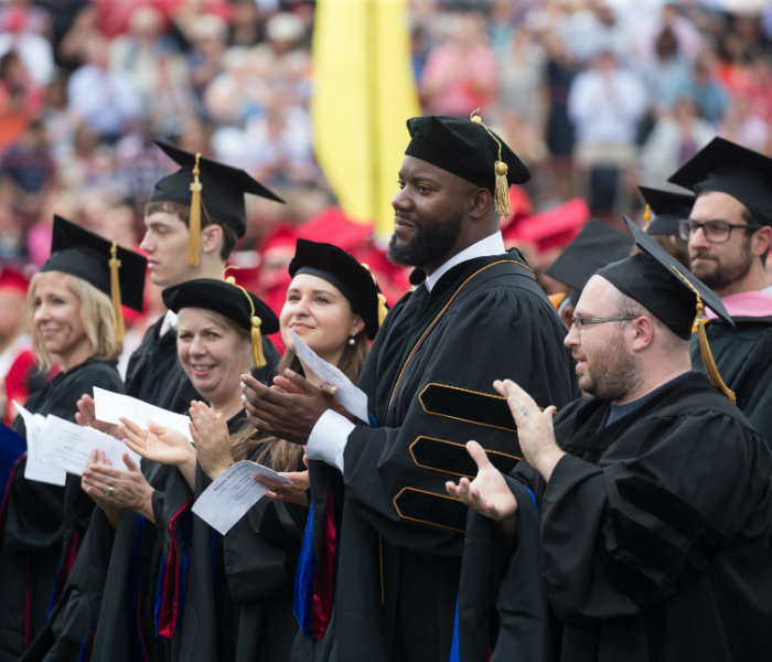  Doctoral graduates at May commencement clapping
