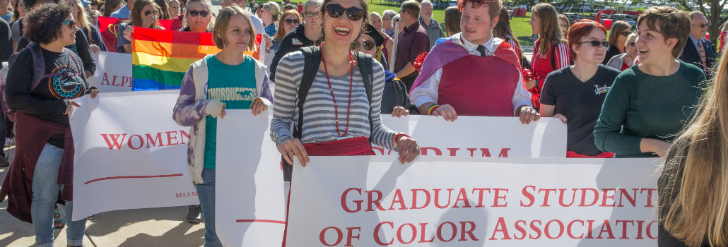  Students holding a banner with the Graduate Students of Color Association on the banner