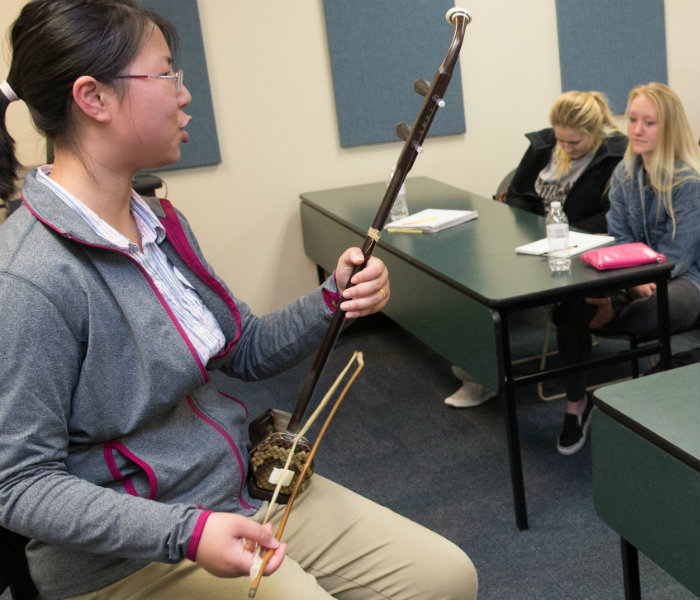  Student in front of a classroom discussing their instrument research