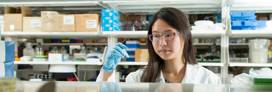  Girl holding a piece of research equipment in a lab