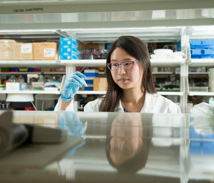  Girl holding a piece of research equipment in a lab