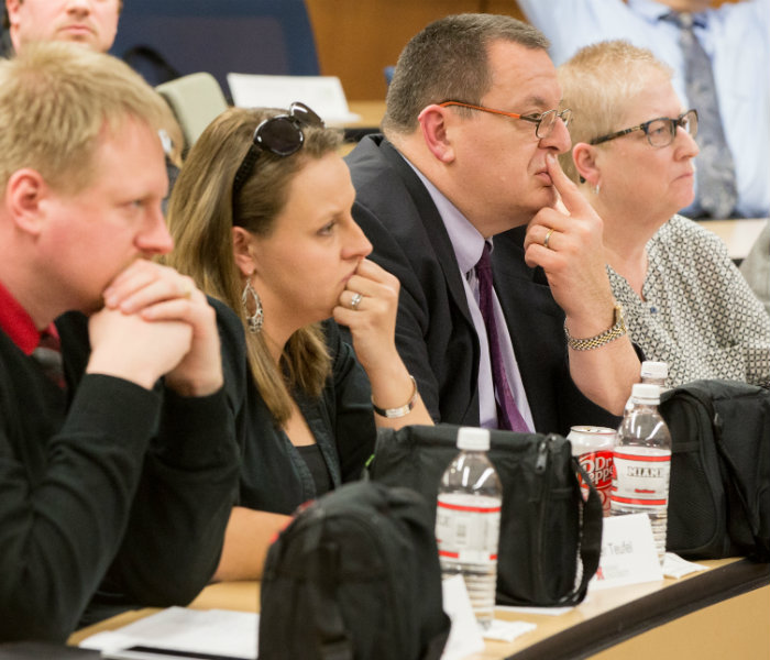 Picture of 3 Minute Thesis judges listening to the presenter