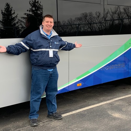 Dale Savage stands in front of the BCRTA bus that he drives as part of the work+ program