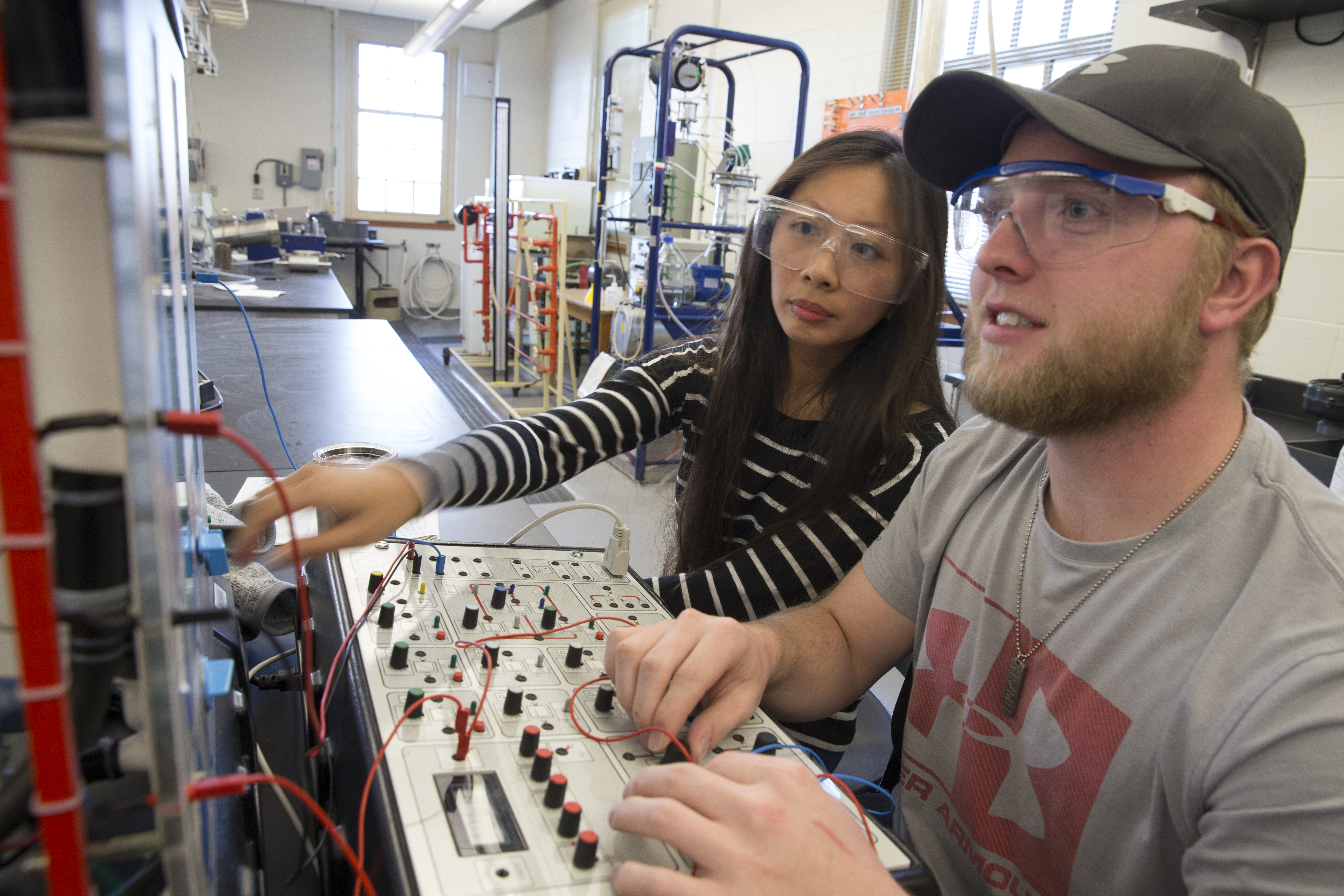 A female and a male engineering students working together in a lab.