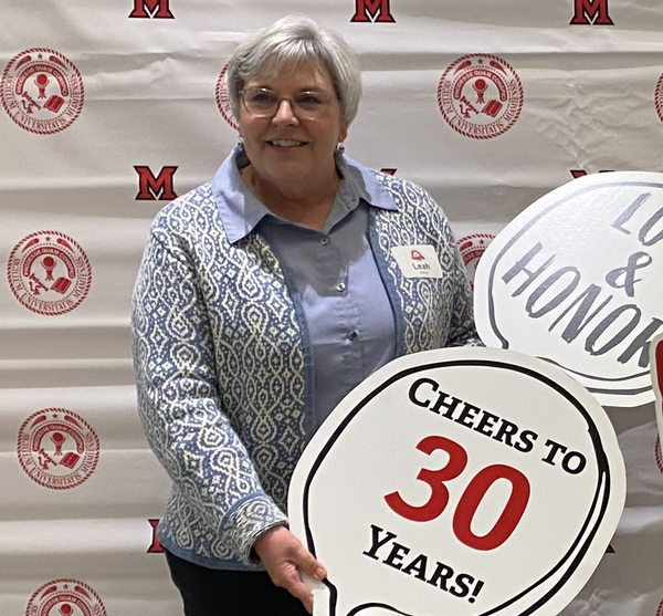 Leah Harris holding a sign that says Cheers to 30 Years
