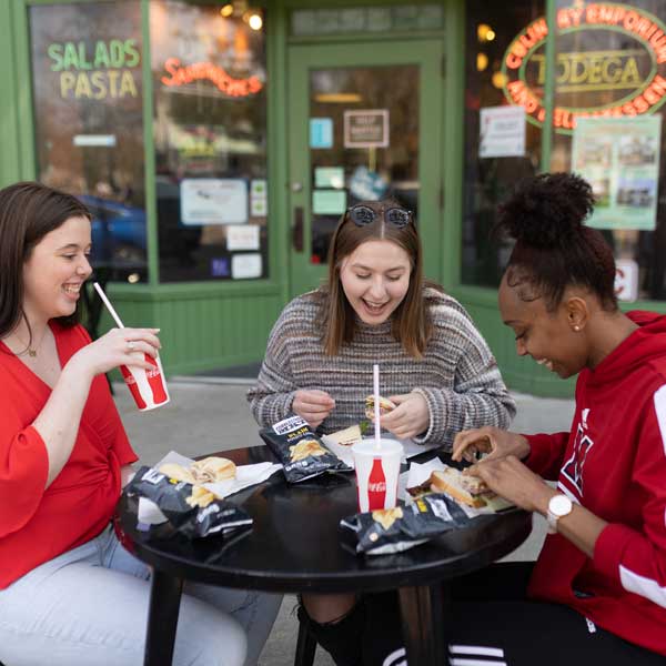 a group of students in uptown Oxford eating at an outdoor table