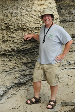 Tim McCoy standing near a rock formation