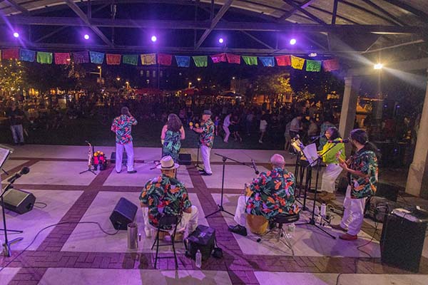 musicians onstage at Uptown Park perform in front of crowd at night