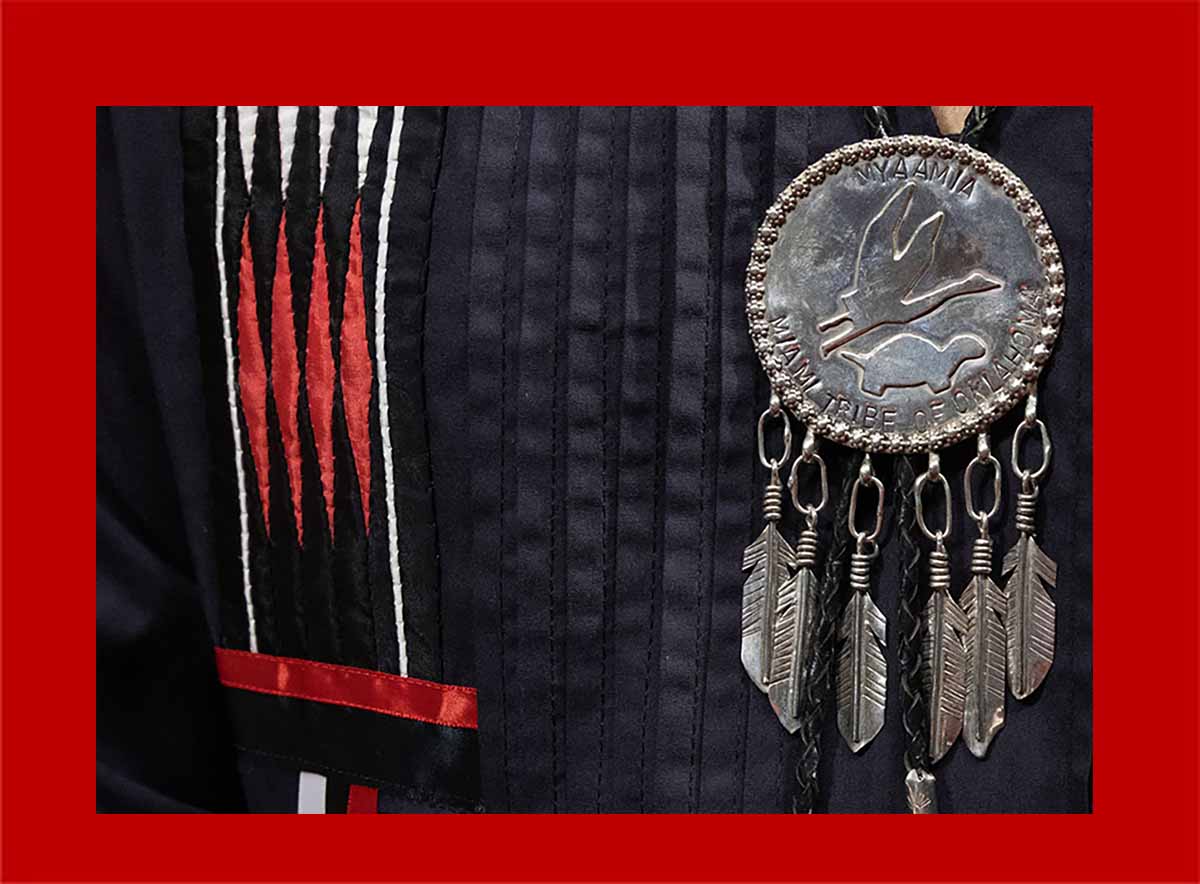 Myaamia ribbonwork and silver medallion with a crane, turtle and feathers