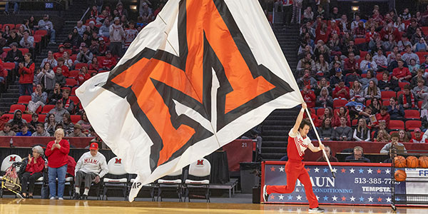 A Miami student with a Miami flag during a basketball game