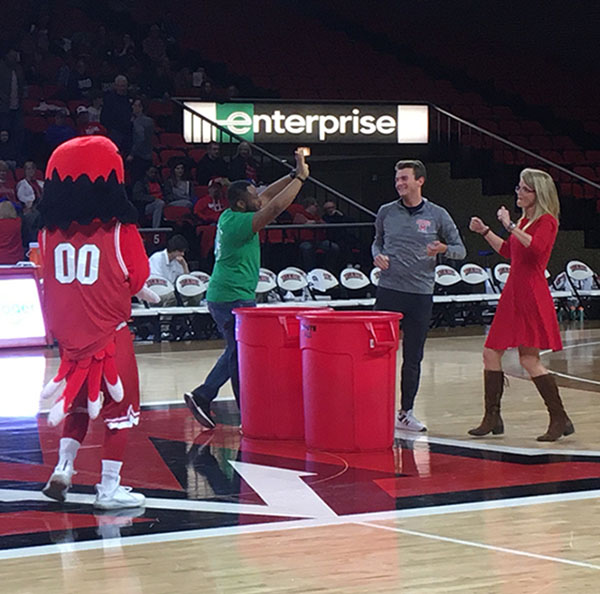 Renate Crawford, Swoop, Cecil Okotah cheer on the basketball court after wining the "recycle this, not that" contest in 2020