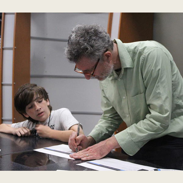 Andy Rice, associate professor of Media, Journalism, and Film, works with a student at Camp Excel (Oxford Observer).