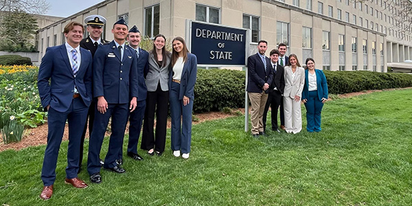 Students pose with Department of State sign
