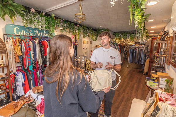 Miami University student Rhett Bilski, right, at the College Artisans Shop with a customer