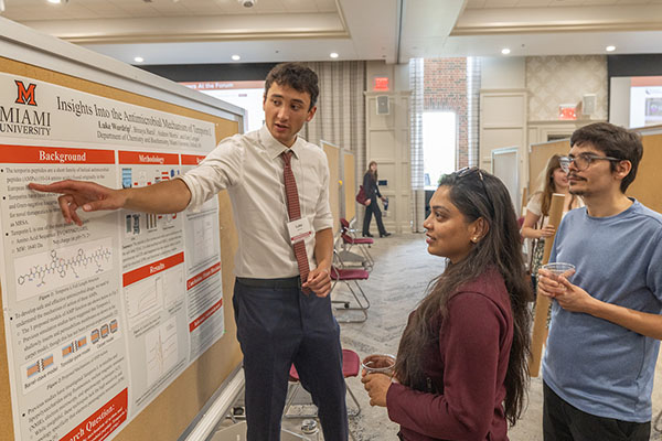 Luke Wardrip presents his research to visitors at the forum