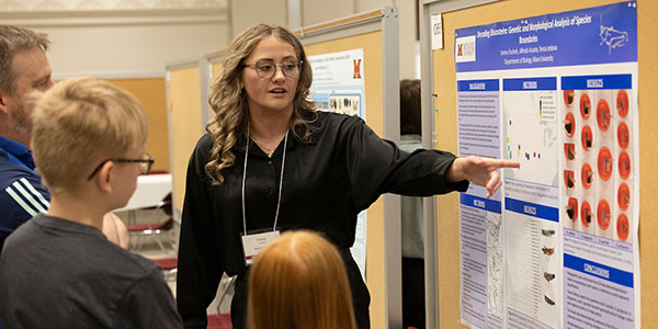 Emma Fischels presents her research to a group of visitors at the forum