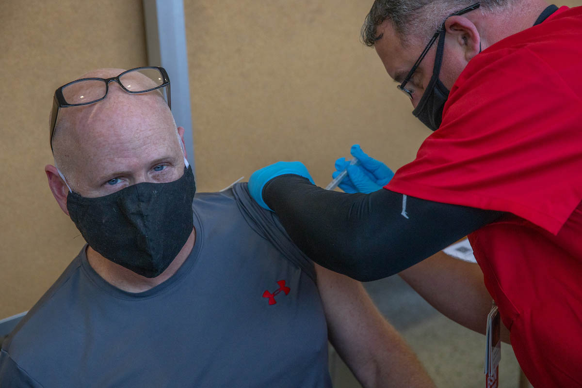 Rod Northcutt, professor, receiving the vaccine from a Miami nursing student