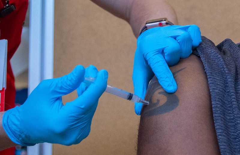 Close up image of a nurse administering the vaccine into a person's shoulder