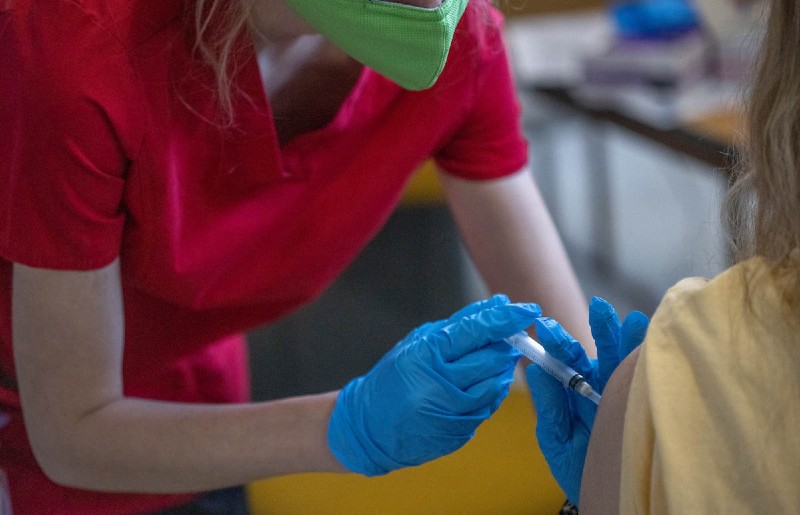 Miami nursing student administering the vaccine to a woman