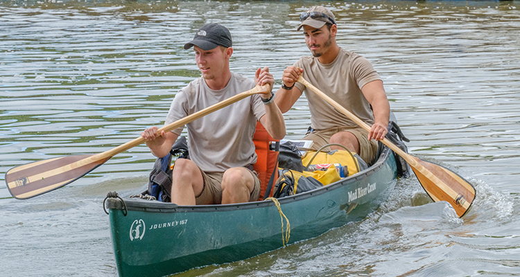  Tyler and Jackson paddling a canoe on the river.