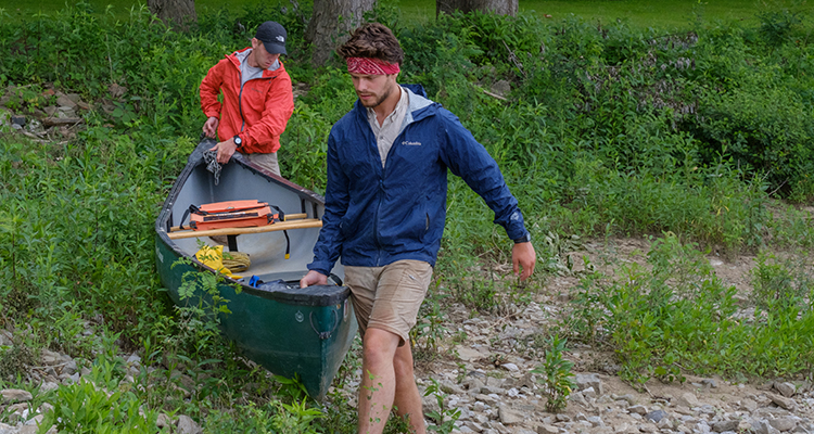 Quinton and Tyler carry the canoe on land