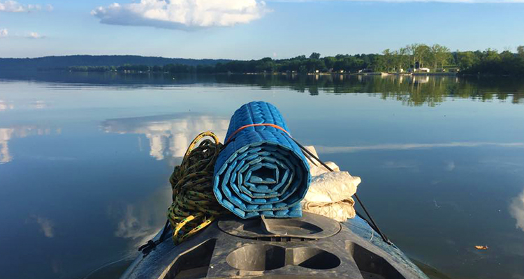 A view of a river from the perspective of a kayak.