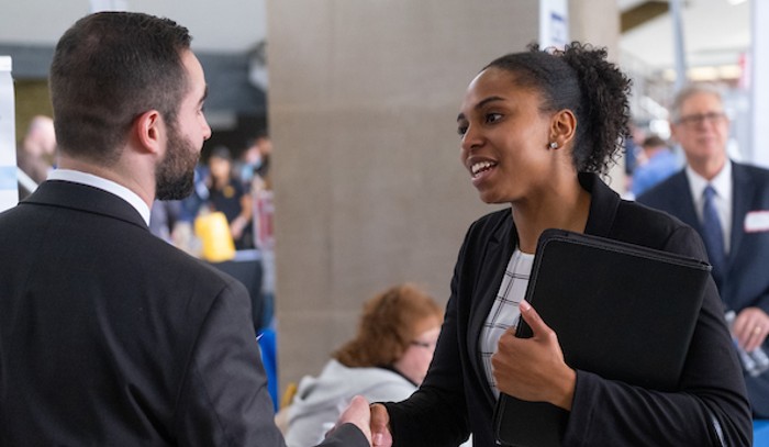 A Miami student shaking hands with a potential employer at the career fair