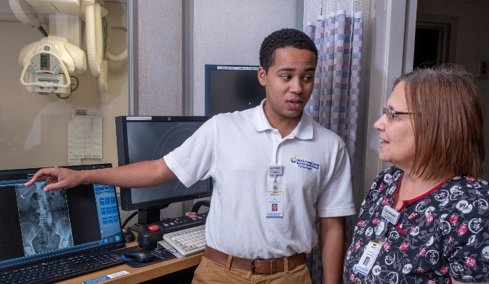 A Miami student with an internship with Tri-Health hospital looking at X-Rays with a supervisor