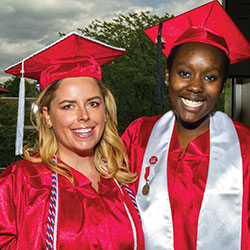 2 students in their graduation cap and gown at the Miami Regionals commencement ceremony. 