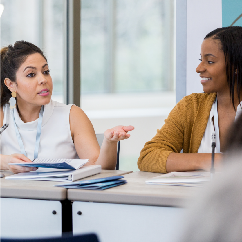 2 women speaking during a meeting.